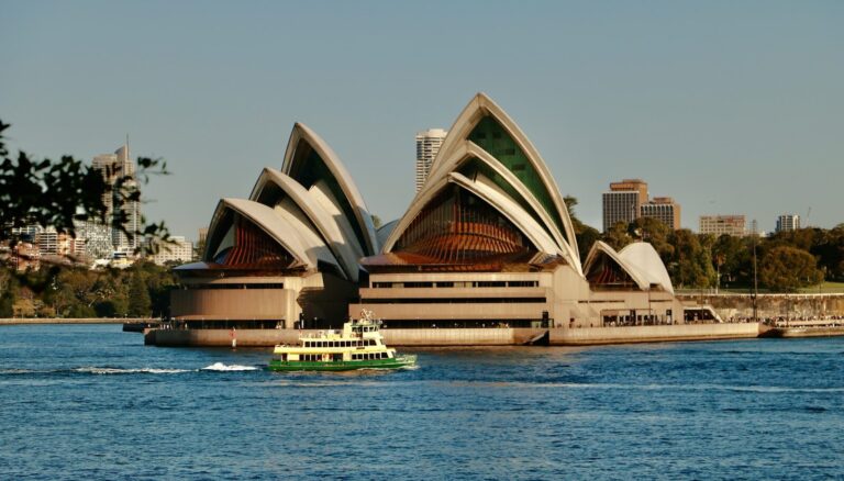 A boat in a body of water near a large building